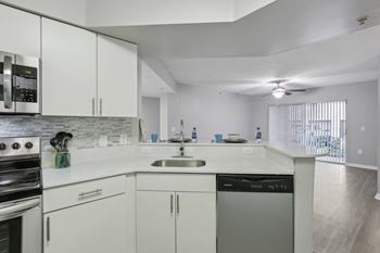 a kitchen with white cabinets and a sink and a stove at Pembroke Pines Landings, Pembroke Pines, Florida